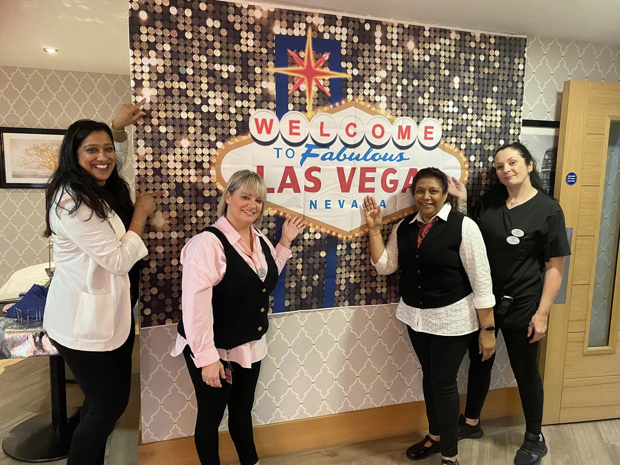 Our staff dressed up in smart clothes in front of a Las Vegas sign for our Casino Morning at Haling Park