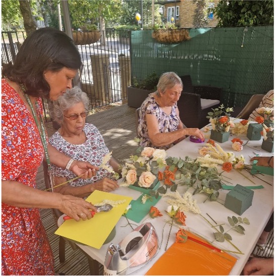 Two residents taking part in a flower arranging class. 