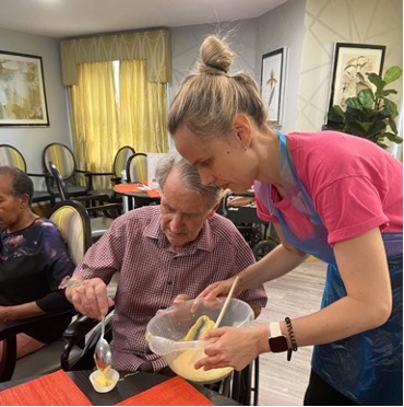 A carer helping a male resident with his baking.