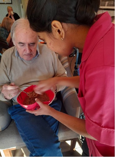 carer helping resident with baking