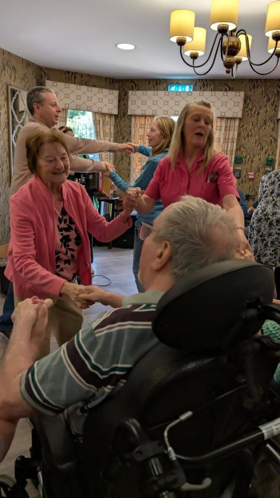 residents dancing with staff in care home smiling at easter events